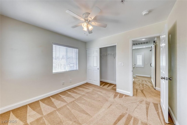 unfurnished bedroom featuring ceiling fan, light carpet, visible vents, baseboards, and a closet