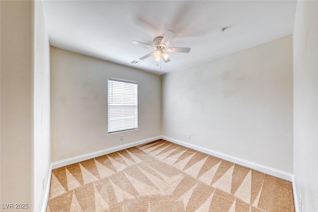 carpeted spare room with ceiling fan, visible vents, and baseboards