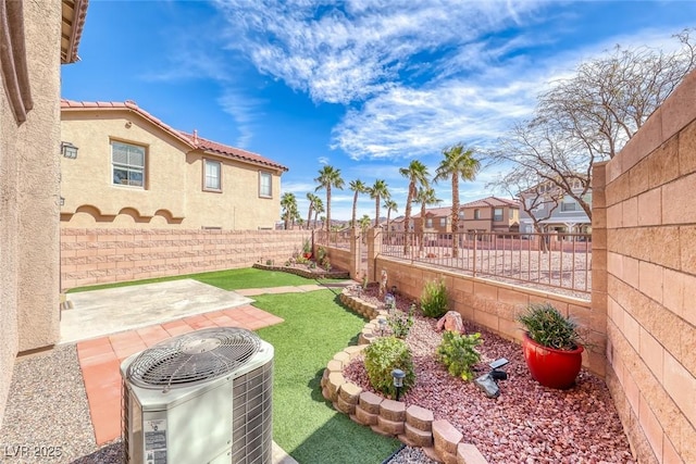 view of yard featuring a patio area, a fenced backyard, a residential view, and central AC