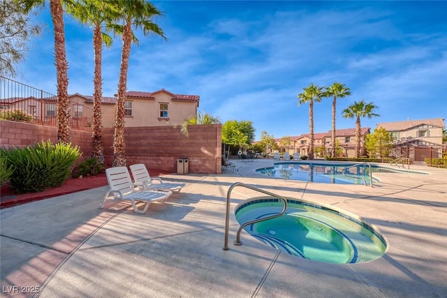 pool with a patio area, a residential view, fence, and a community hot tub