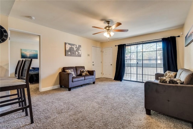 carpeted living area featuring ceiling fan and baseboards