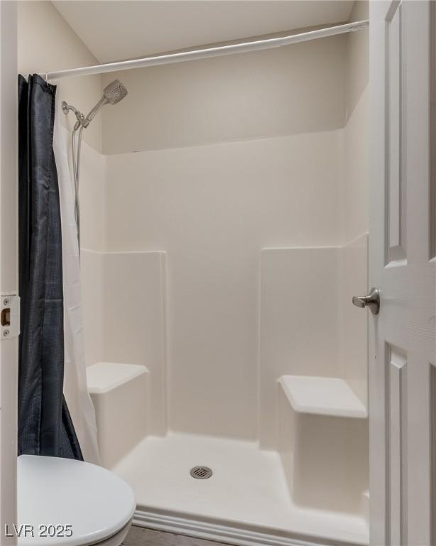 bathroom featuring toilet and a shower with curtain