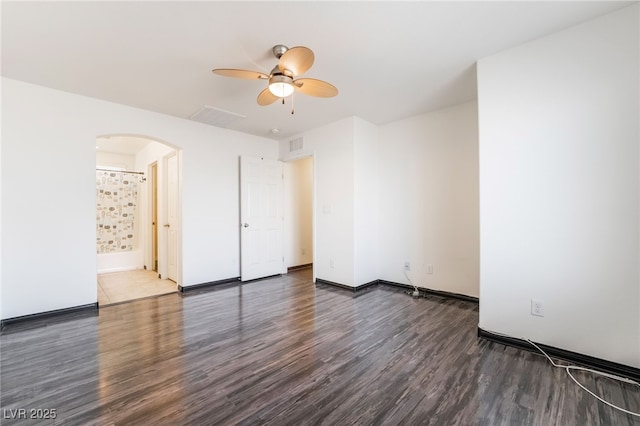 unfurnished bedroom with arched walkways, visible vents, ceiling fan, wood finished floors, and baseboards