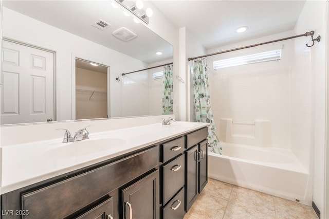 bathroom with visible vents, shower / bath combo with shower curtain, a sink, and tile patterned floors