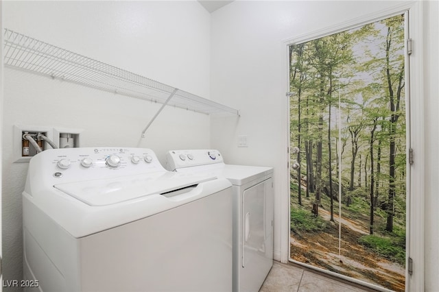 washroom with washing machine and dryer, laundry area, and light tile patterned floors