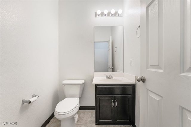 half bathroom featuring baseboards, vanity, toilet, and tile patterned floors