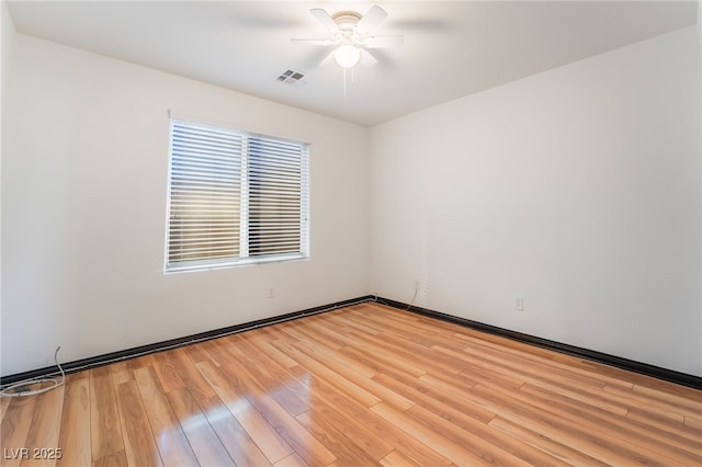 spare room featuring light wood-style floors, ceiling fan, and visible vents