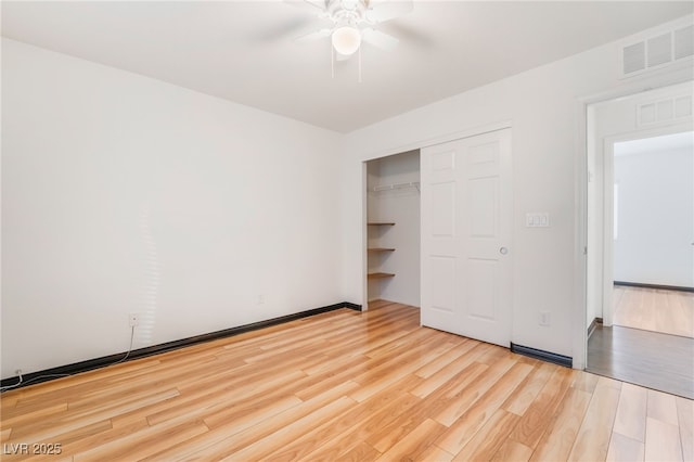 unfurnished bedroom featuring a ceiling fan, a closet, visible vents, and wood finished floors