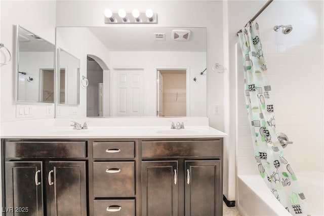 full bath featuring shower / bath combination with curtain, double vanity, and a sink