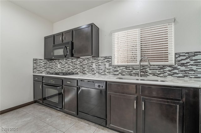 kitchen with black appliances, tasteful backsplash, light countertops, and a sink