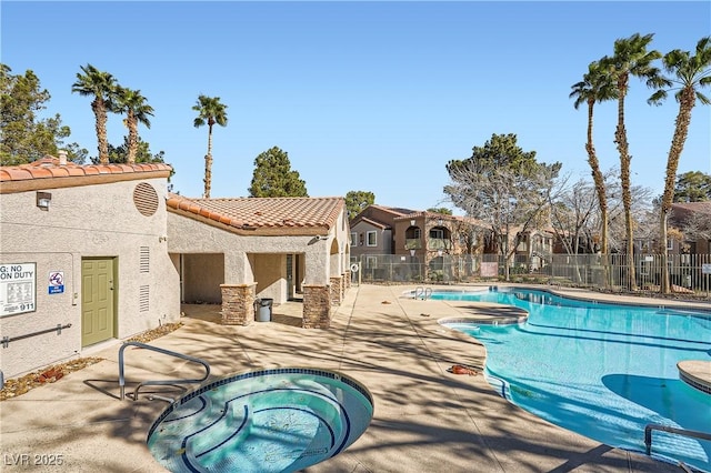 community pool with a community hot tub, a patio area, and fence