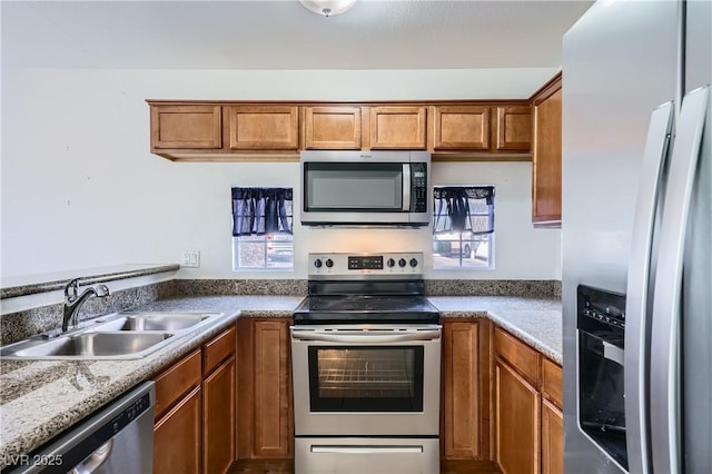 kitchen with stainless steel appliances, brown cabinets, and a sink