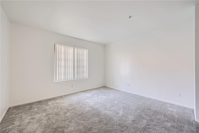 unfurnished room featuring carpet flooring and baseboards