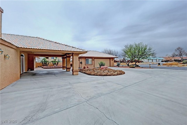 exterior space with a tile roof and stucco siding