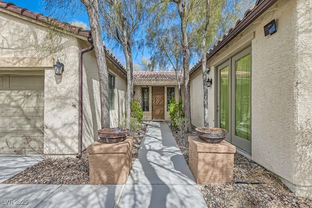 doorway to property with stucco siding and a tile roof