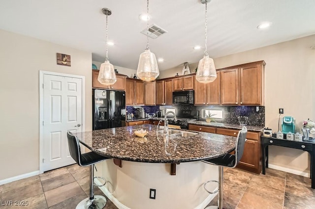 kitchen with black appliances, tasteful backsplash, visible vents, and a sink