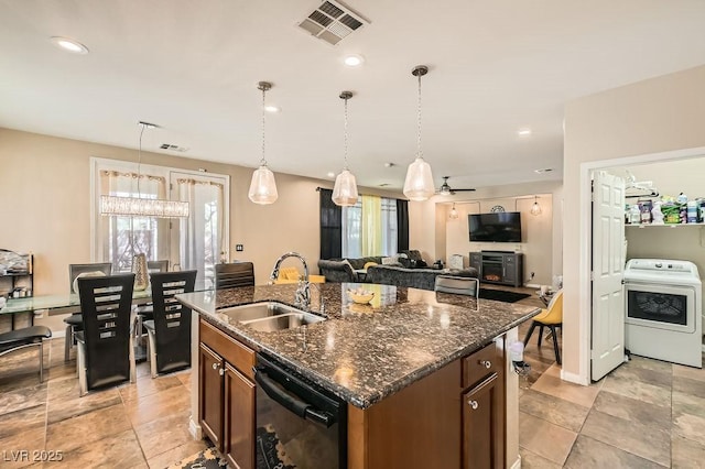 kitchen featuring visible vents, washer / clothes dryer, a sink, hanging light fixtures, and dishwasher