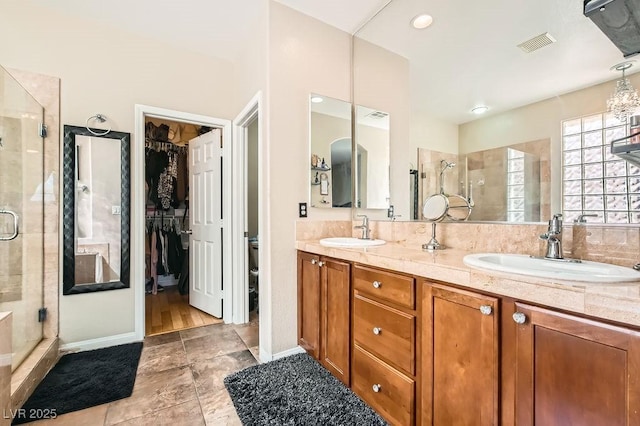 full bathroom with a shower stall, double vanity, visible vents, and a sink