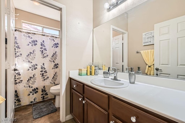 bathroom featuring vanity, curtained shower, and toilet