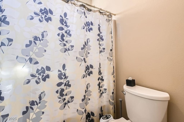 bathroom featuring a shower with shower curtain and toilet