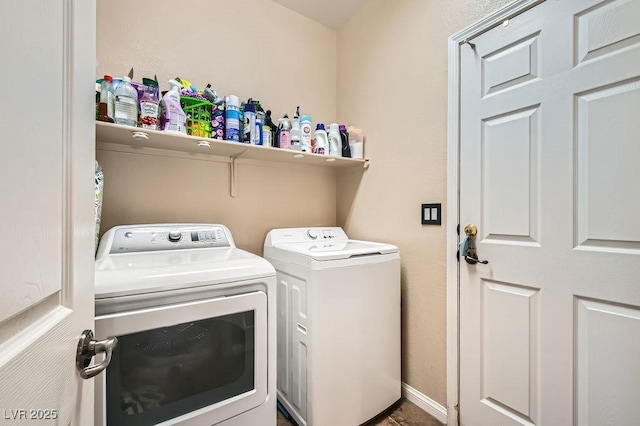 washroom with baseboards, washing machine and dryer, and laundry area