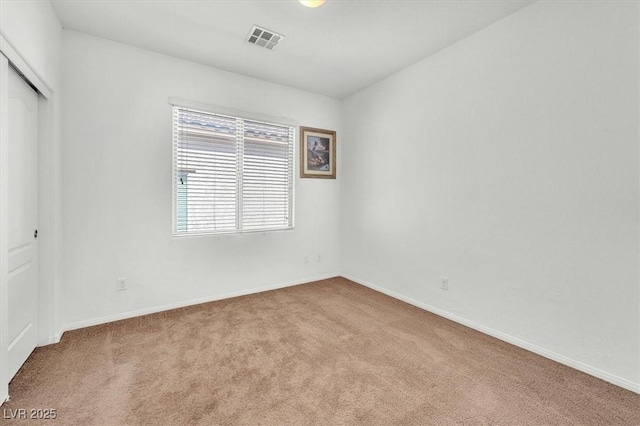 carpeted spare room with baseboards and visible vents