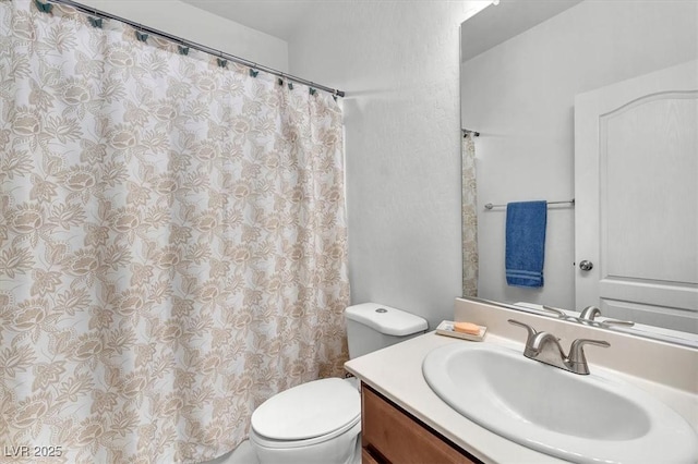 full bath with curtained shower, vanity, and toilet