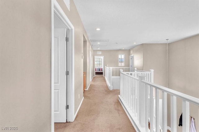 corridor with recessed lighting, baseboards, light colored carpet, and an upstairs landing