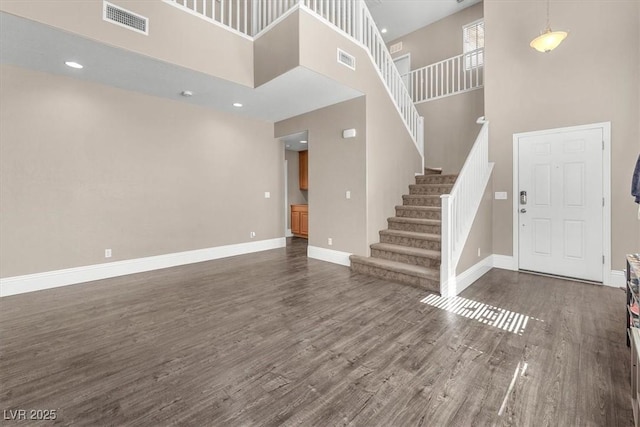 entryway featuring dark wood-type flooring, visible vents, stairway, and baseboards