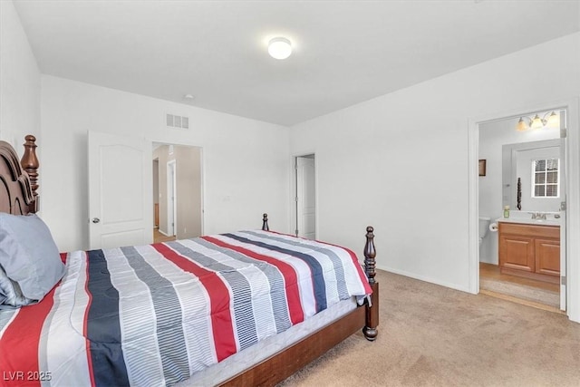 bedroom featuring visible vents, light carpet, connected bathroom, a sink, and baseboards