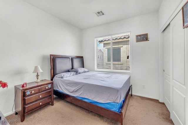 carpeted bedroom with a closet, visible vents, and baseboards