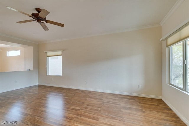 spare room featuring ceiling fan, ornamental molding, light wood-type flooring, and baseboards