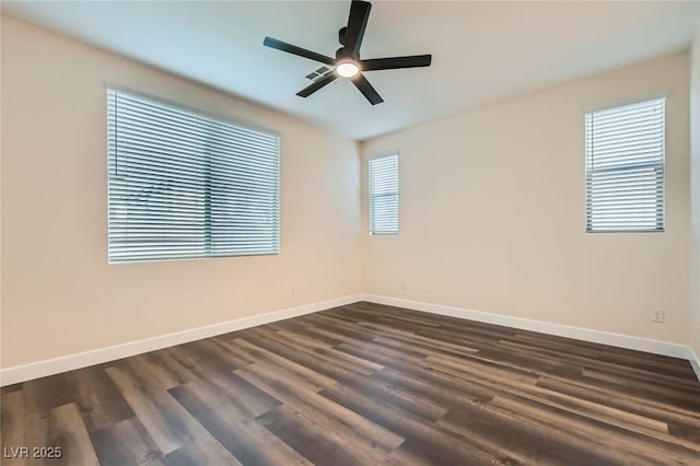 spare room featuring dark wood-style floors, baseboards, and a ceiling fan