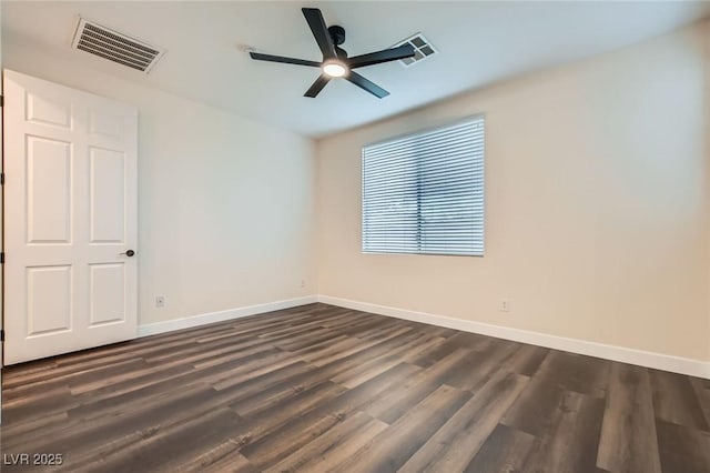 unfurnished room featuring baseboards, visible vents, and dark wood-type flooring