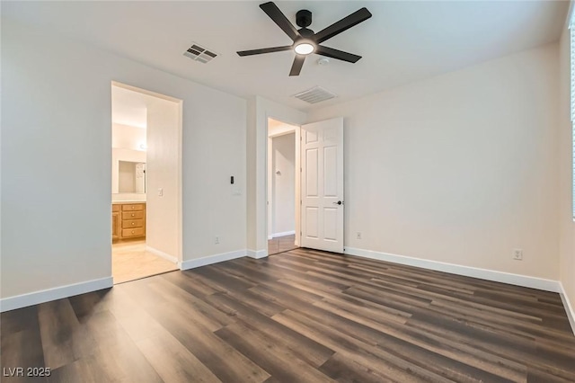 unfurnished bedroom with baseboards, visible vents, and dark wood-type flooring