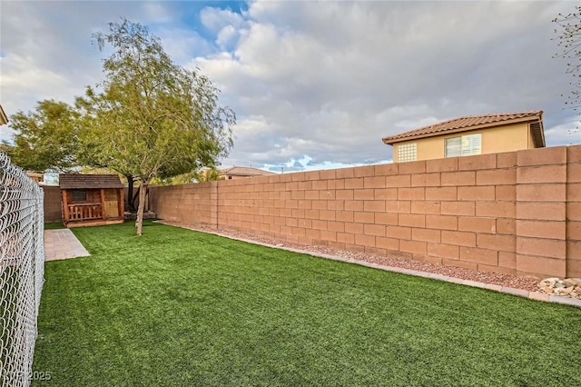 view of yard featuring a fenced backyard, an outdoor structure, and a shed