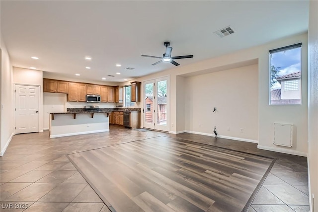 unfurnished living room with baseboards, tile patterned floors, visible vents, and recessed lighting