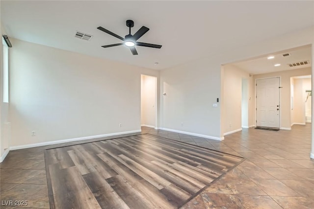 unfurnished room with visible vents, ceiling fan, and baseboards