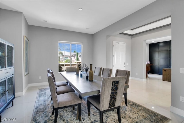 dining space with baseboards and light tile patterned floors