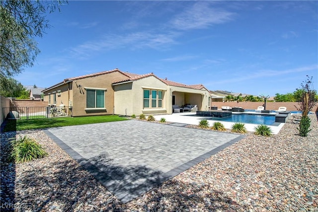 back of house with a fenced in pool, a patio, a fenced backyard, a tile roof, and stucco siding