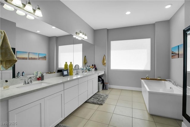 full bath with double vanity, a soaking tub, a sink, and tile patterned floors