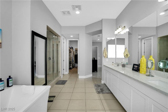 full bath with a shower stall, a spacious closet, visible vents, and tile patterned flooring