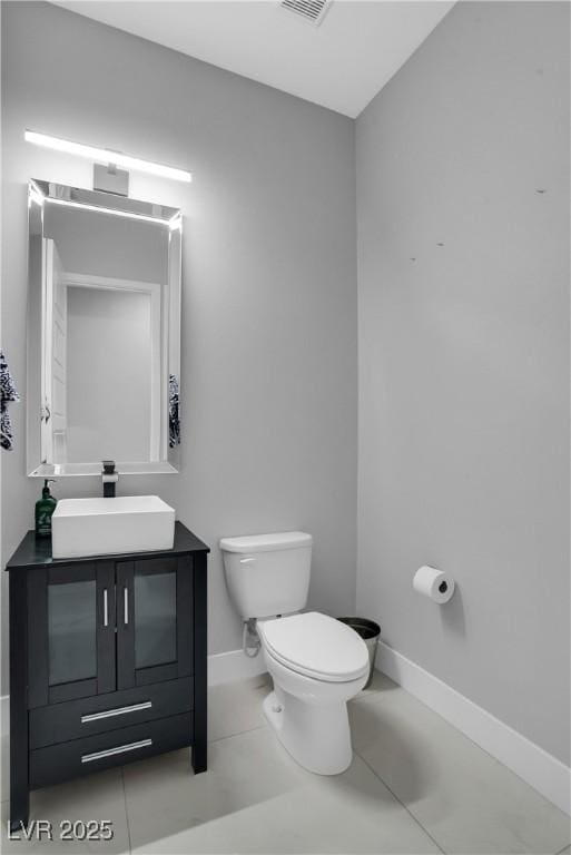 bathroom with visible vents, toilet, vanity, baseboards, and tile patterned floors