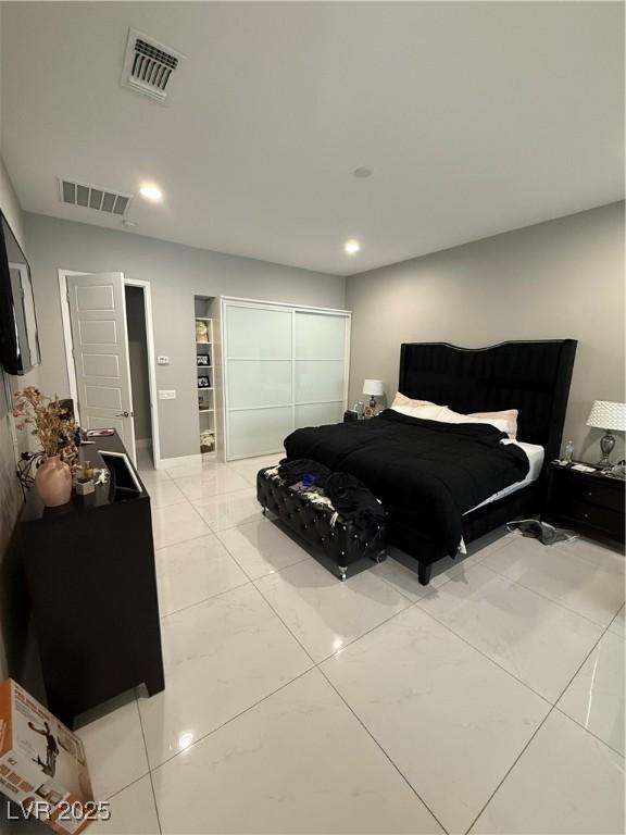 bedroom with a closet, visible vents, and recessed lighting