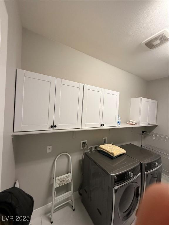 washroom with cabinet space, visible vents, and separate washer and dryer