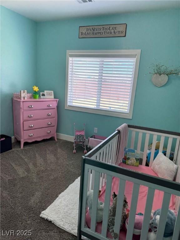 carpeted bedroom featuring a crib, visible vents, and baseboards