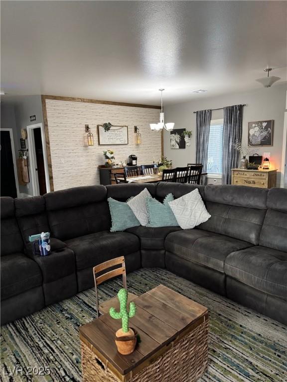 living room featuring brick wall and a chandelier