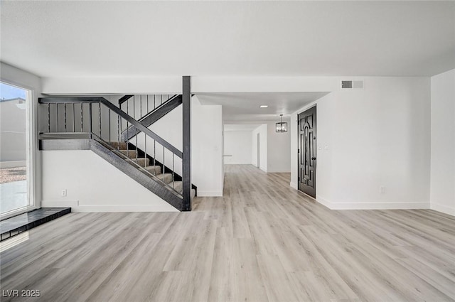 interior space with visible vents, stairway, baseboards, and wood finished floors