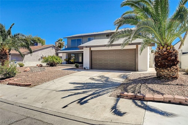 view of front of property with driveway, an attached garage, and stucco siding