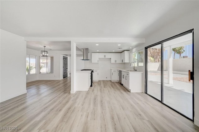 kitchen featuring baseboards, white cabinets, stainless steel appliances, extractor fan, and light wood-type flooring